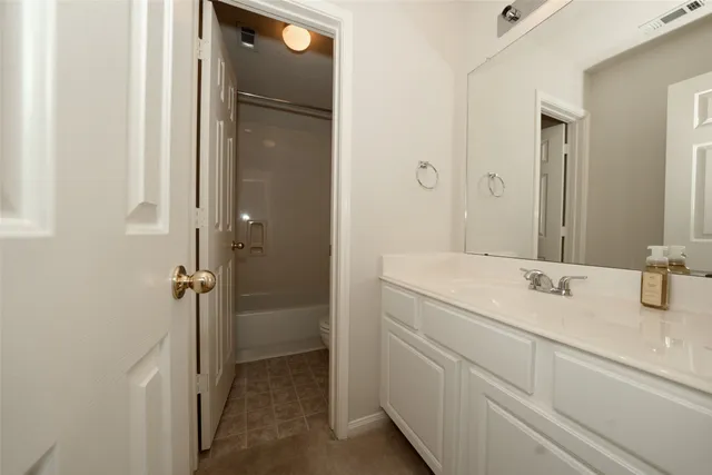 a bathroom with a double vanity sink a mirror and a bathtub