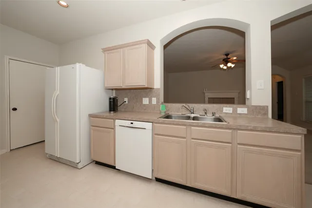 a kitchen with white cabinets and white appliances