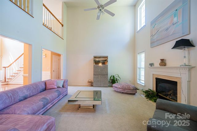a living room with furniture a fireplace and a large window