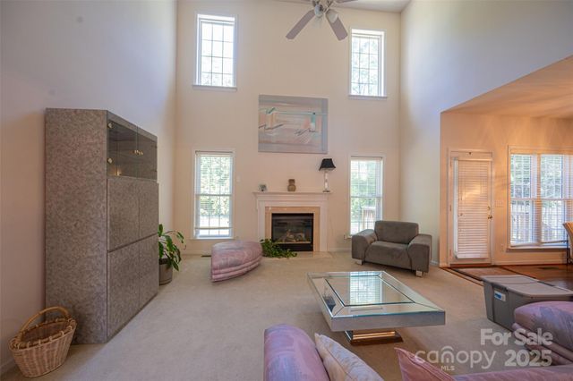 a living room with furniture large window and fireplace