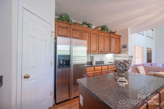 a kitchen with stainless steel appliances granite countertop a refrigerator a stove and a sink