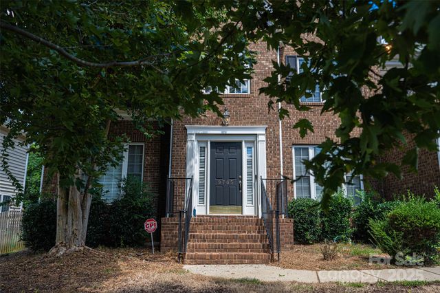 a front view of a house with a tree