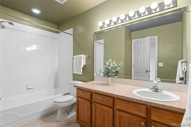a bathroom with a granite countertop sink toilet a large mirror a bathtub and shower