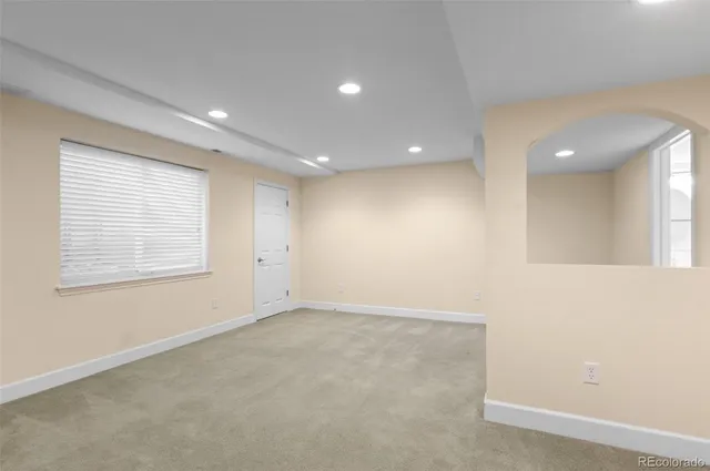 an empty room with a kitchen space and windows