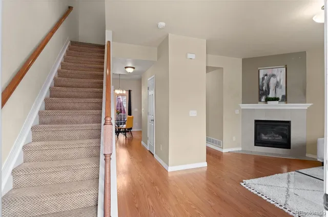 a view of a livingroom with wooden floor and a fireplace