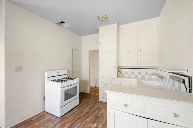 a kitchen with white cabinets and white appliances
