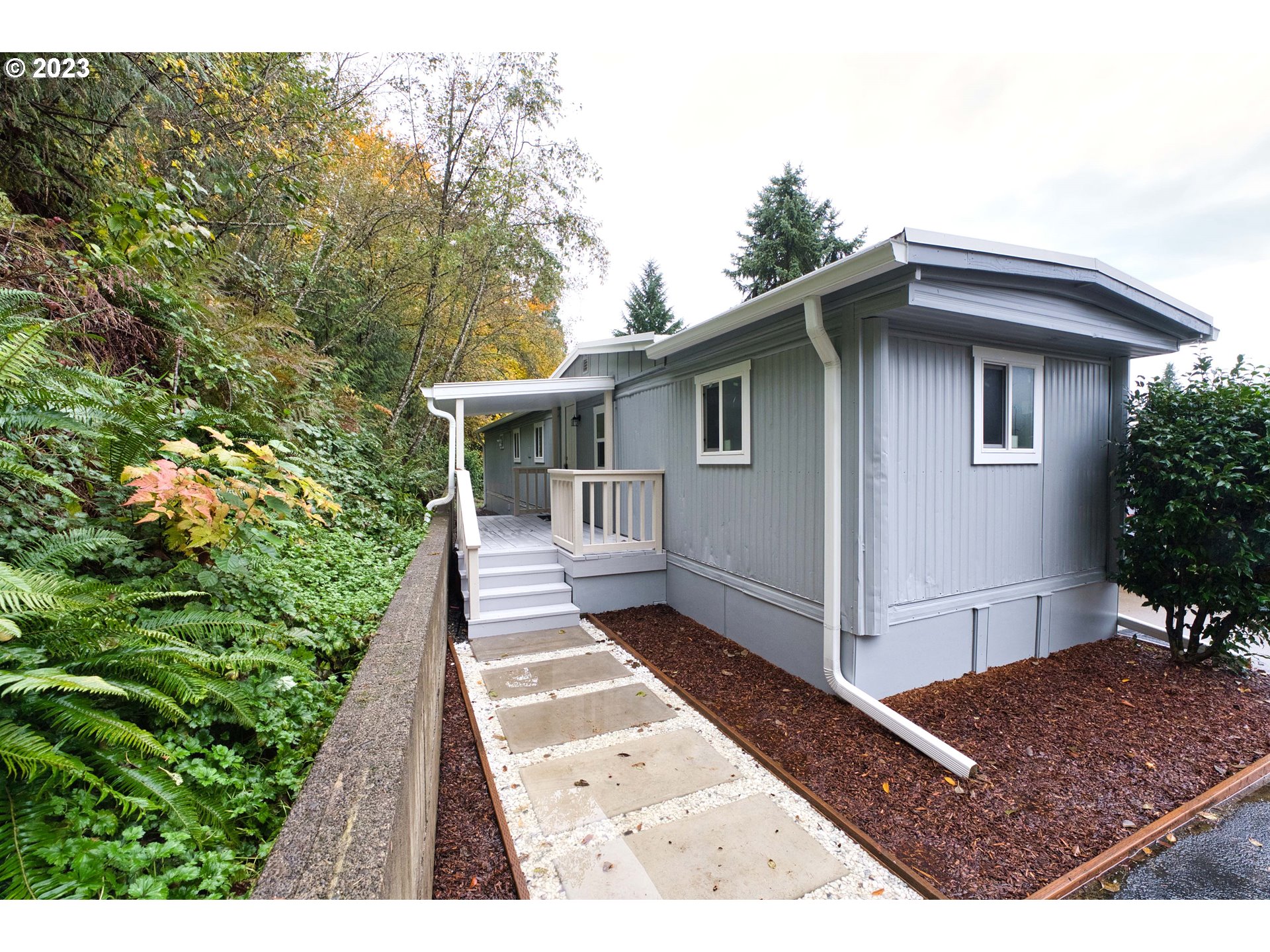 a view of a house with a small yard and potted plants