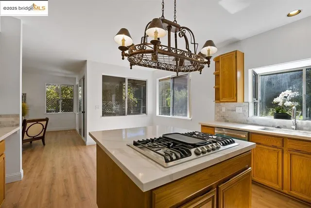 a kitchen with a stove a sink a window and dining table