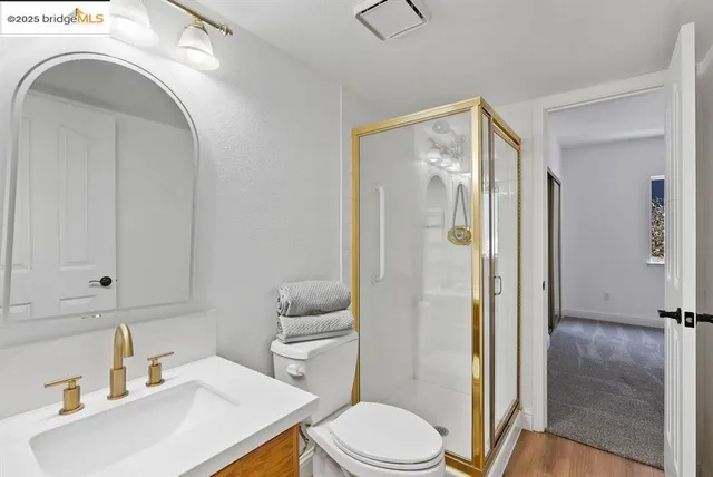 a bathroom with a sink a toilet and shower