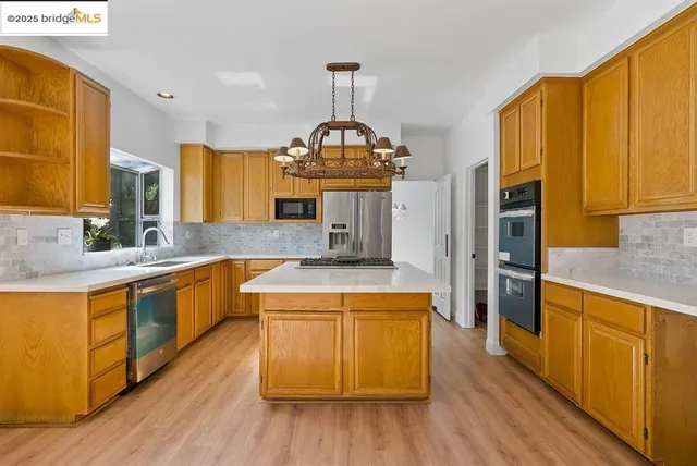 a kitchen with stainless steel appliances granite countertop wooden floors and stove