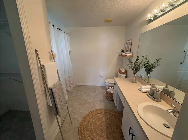 a bathroom with a sink vanity granite and toilet