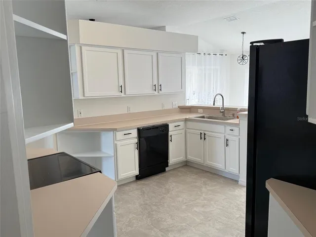 a kitchen with a sink a stove a refrigerator and cabinets