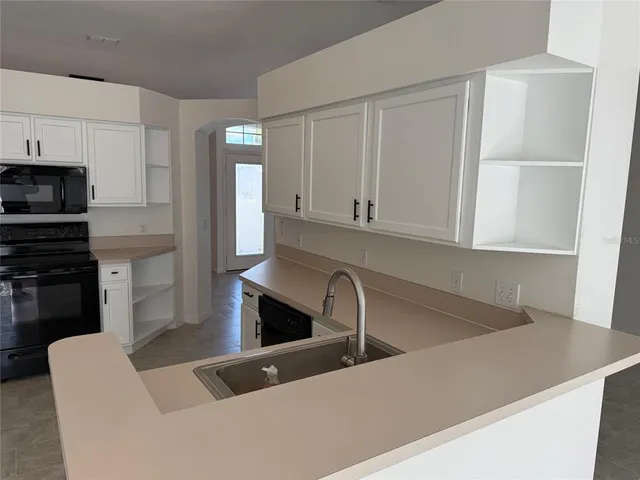 a kitchen with stainless steel appliances granite countertop a sink a stove and a refrigerator