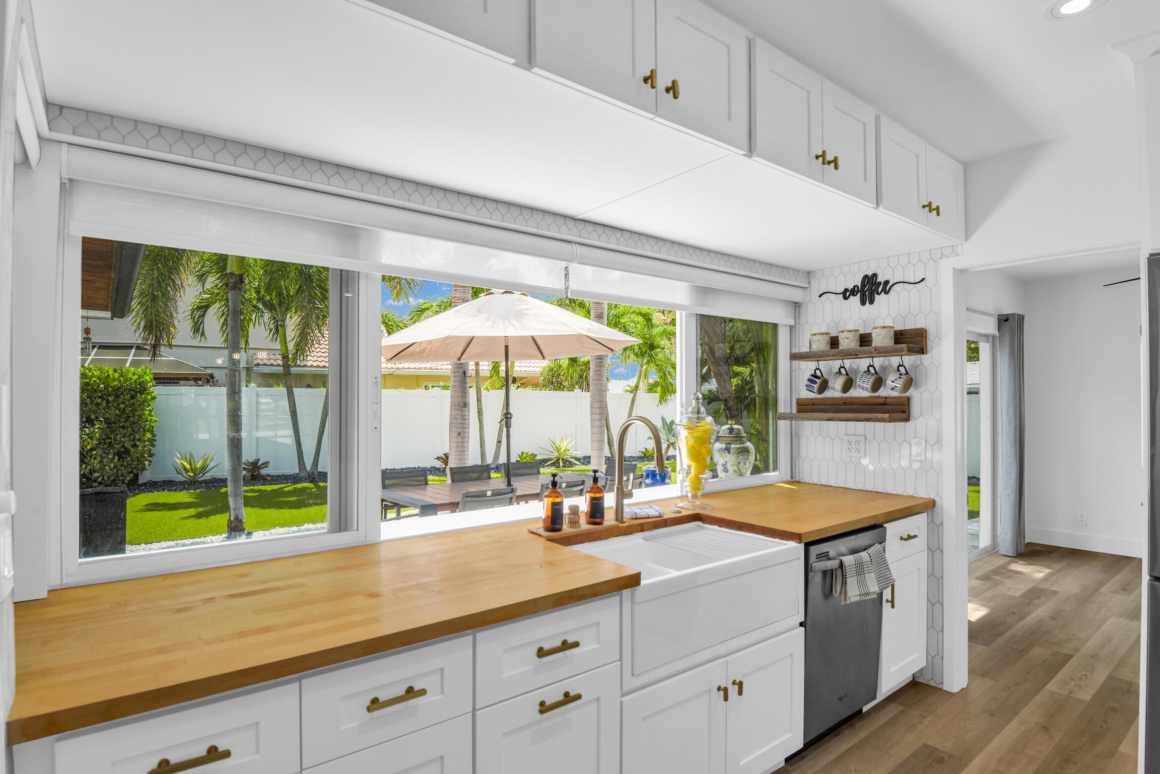 701 Appleby Street Boca Raton, FL 33487 - Photo 9 of 47 a kitchen with stainless steel appliances kitchen island a large window and cabinets