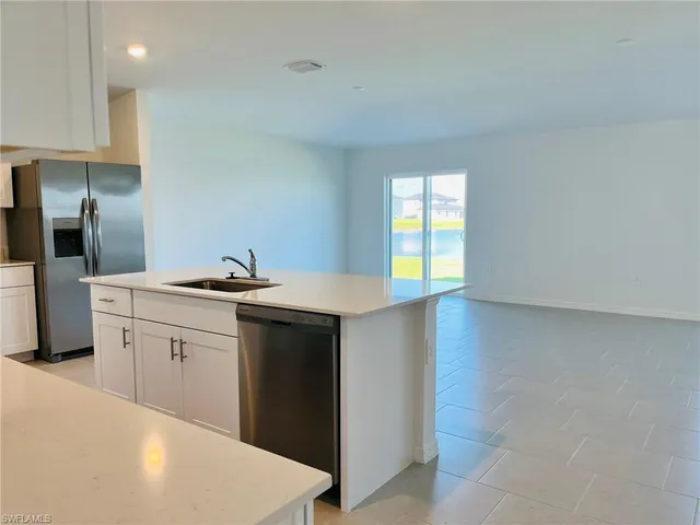 a kitchen with granite countertop a sink and cabinets