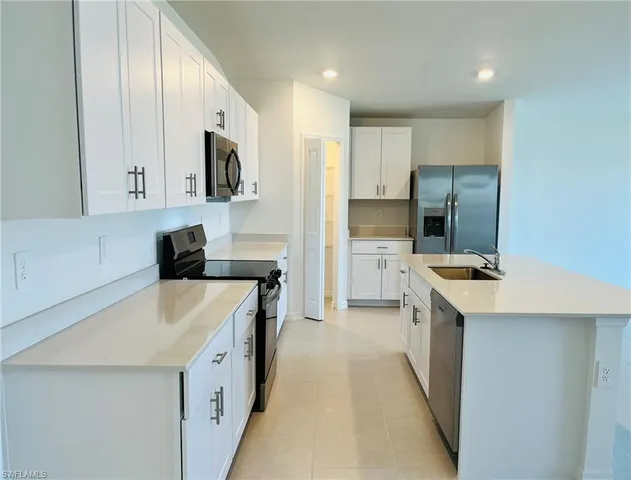 a kitchen with stainless steel appliances a sink stove and refrigerator