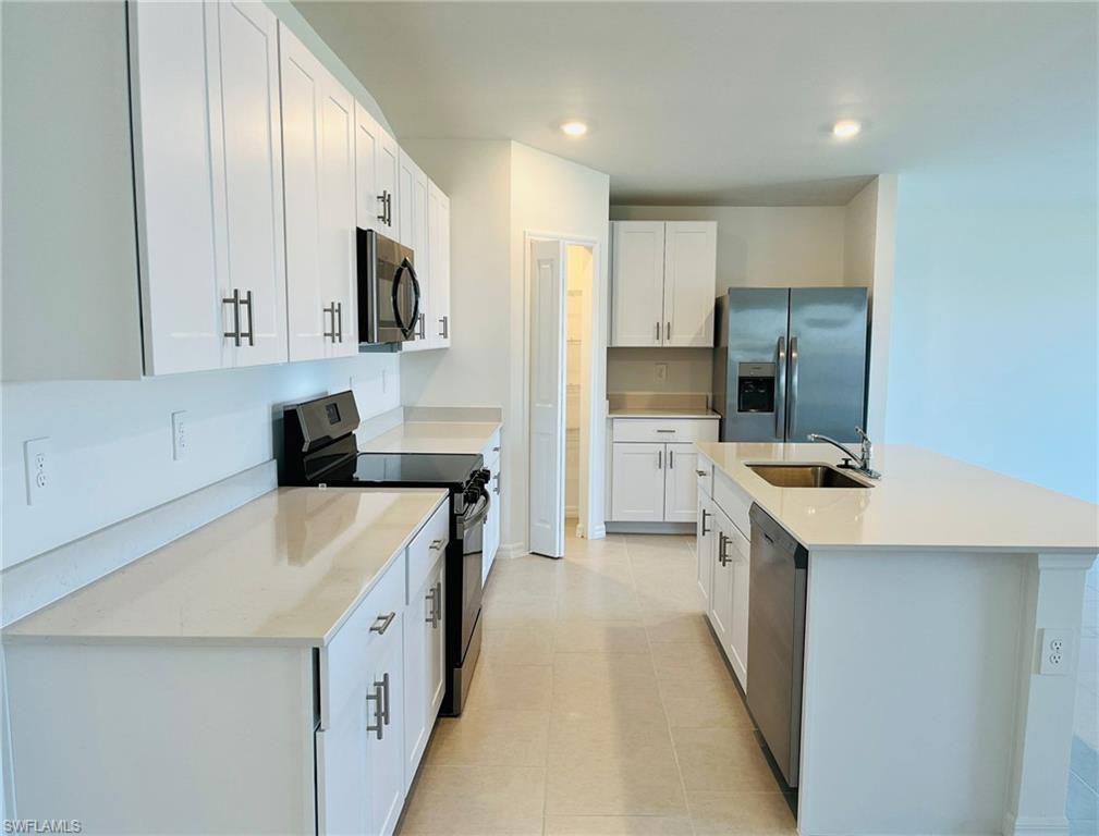 17603 Paradiso Way North Fort Myers, FL 33917 - Photo 5 of 27 a kitchen with stainless steel appliances a sink stove and refrigerator