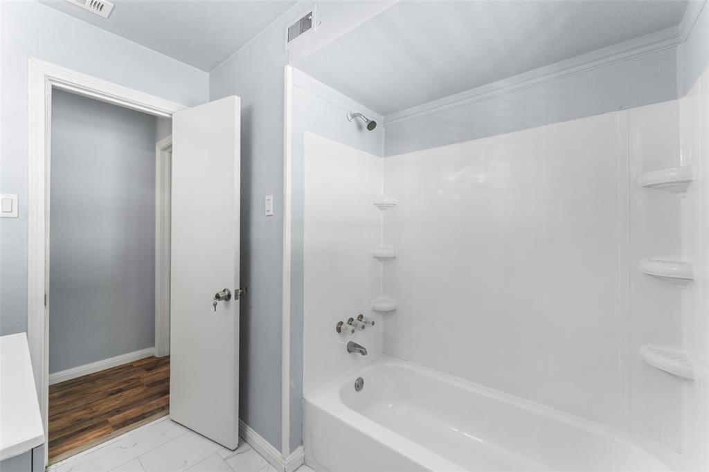 612 East 8th Street Kemp, TX 75143 - Photo 20 of 25 White bathtub and shower combination with integrated shelving