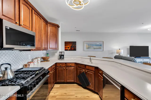 a kitchen with stainless steel appliances a sink dishwasher stove and oven with cabinets