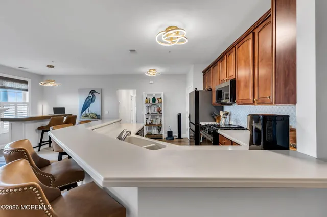 a view of a kitchen with kitchen island a counter top space a sink and cabinets