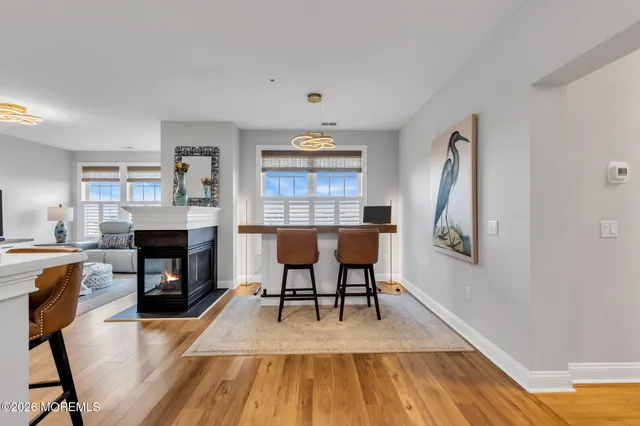 a living room with furniture a fireplace and a dining table with wooden floor