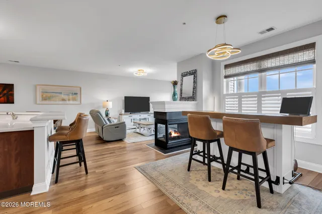 a living room with furniture a flat screen tv and kitchen view