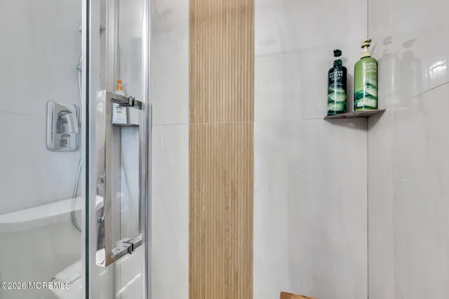 a bathroom with a mirror and shower
