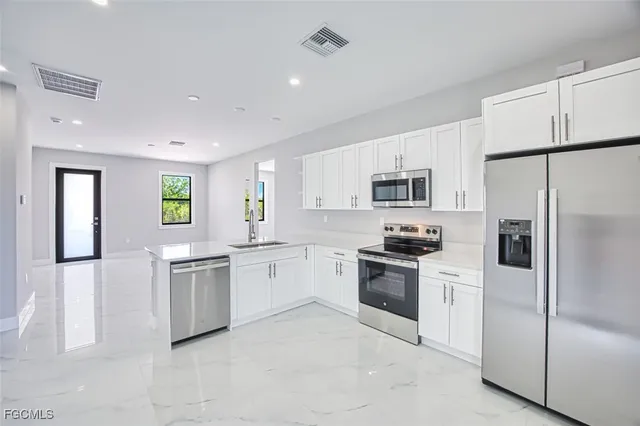 a kitchen with granite countertop stainless steel appliances and refrigerator