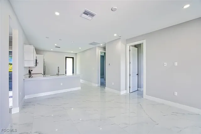 a view of a big room with kitchen view and windows