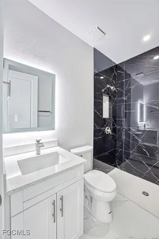 a bathroom with a sink a toilet and shower