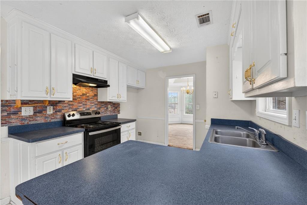 20 Crooked Creek Way Covington, GA 30016 - Photo 20 of 59 a kitchen with granite countertop a stove and a refrigerator