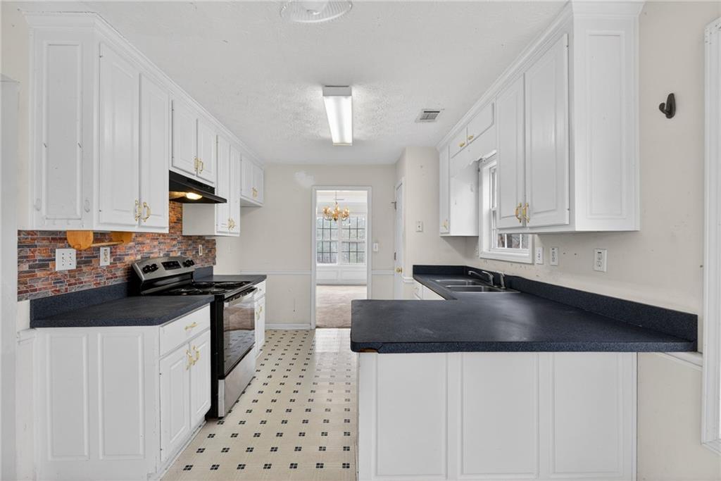 20 Crooked Creek Way Covington, GA 30016 - Photo 21 of 59 a kitchen with granite countertop a sink a stove and cabinets