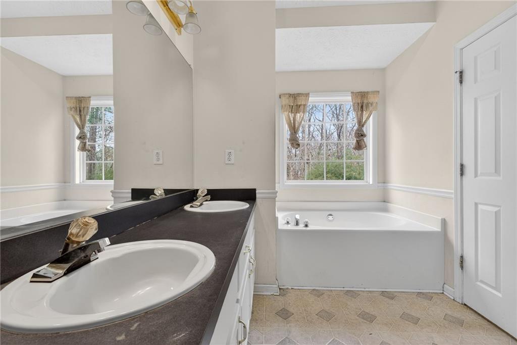 20 Crooked Creek Way Covington, GA 30016 - Photo 32 of 59 a bathroom with a granite countertop tub a sink and a window