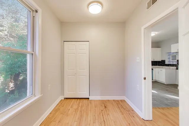 a view of a room with wooden floor closet and windows