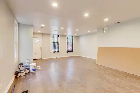 an empty room with wooden floor and furniture