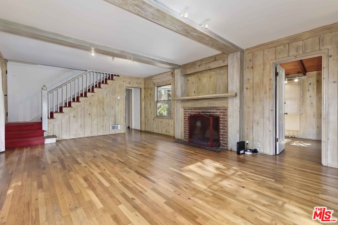 363 West Channel Road Santa Monica, CA 90402 - Photo 5 of 21 a view of an empty room with wooden floor fireplace and a window
