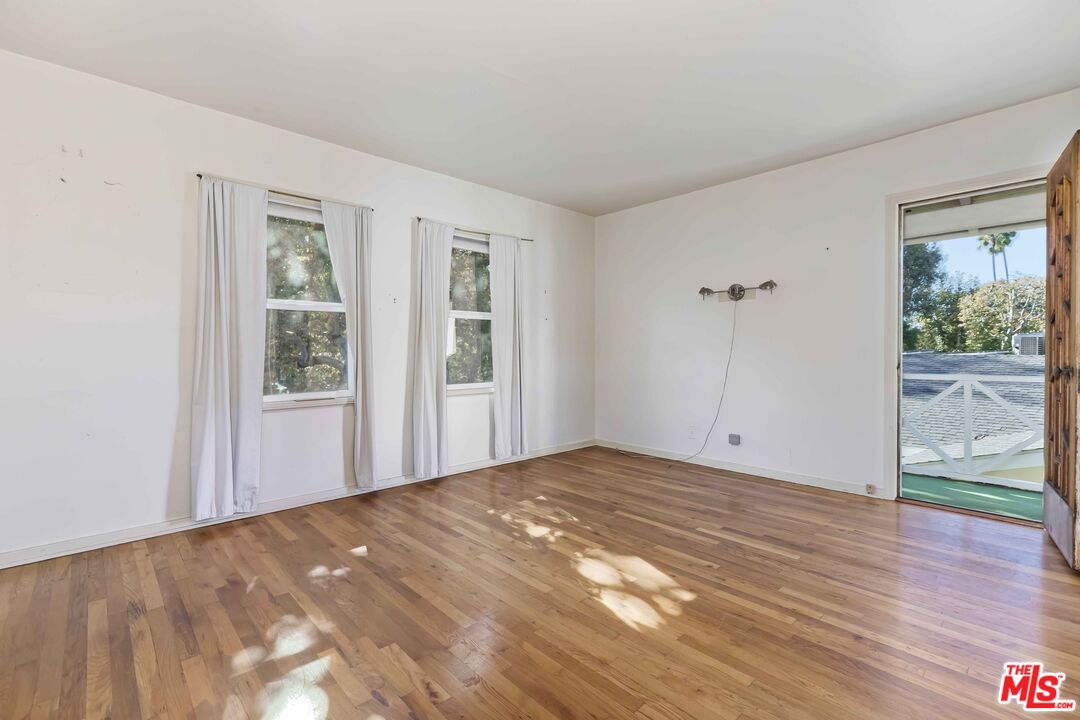 363 West Channel Road Santa Monica, CA 90402 - Photo 10 of 21 a view of an empty room with wooden floor and a window