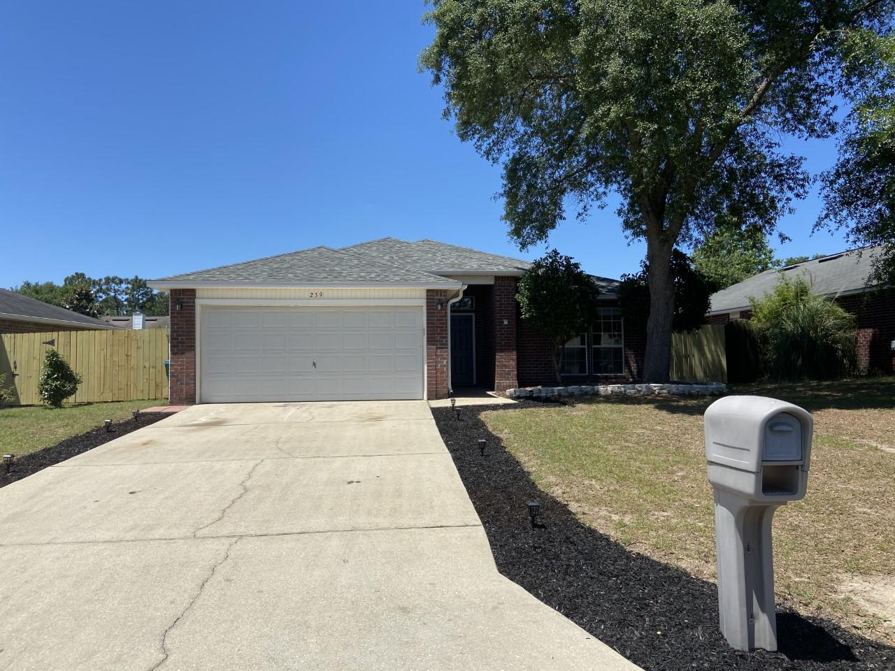 239 Limestone Circle Crestview, FL 32539 - Photo 1 of 15 a front view of a house with garden yard and tree
