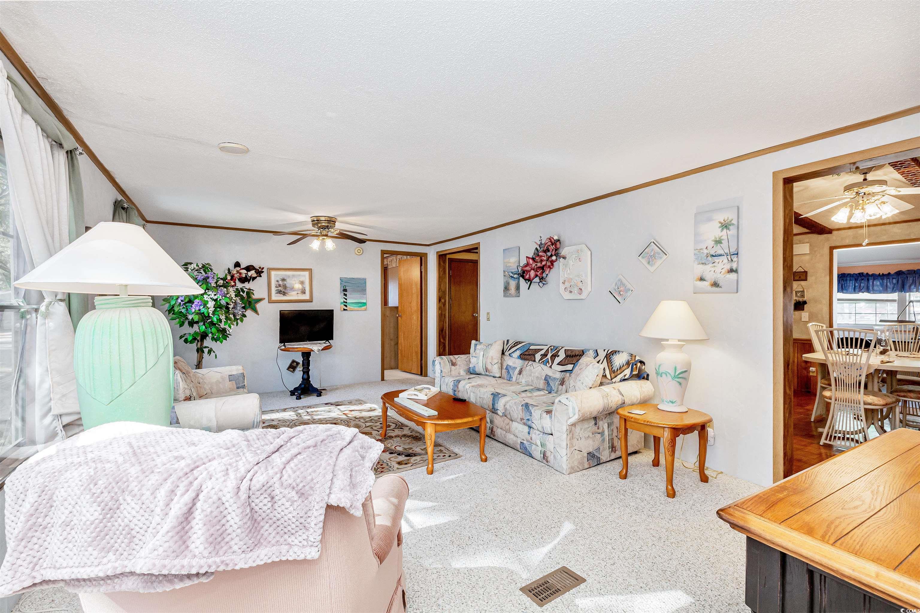 494 Clubhouse Road Murrells Inlet, SC 29576 - Photo 11 of 26 Living area with ceiling fan, carpet flooring, and crown molding