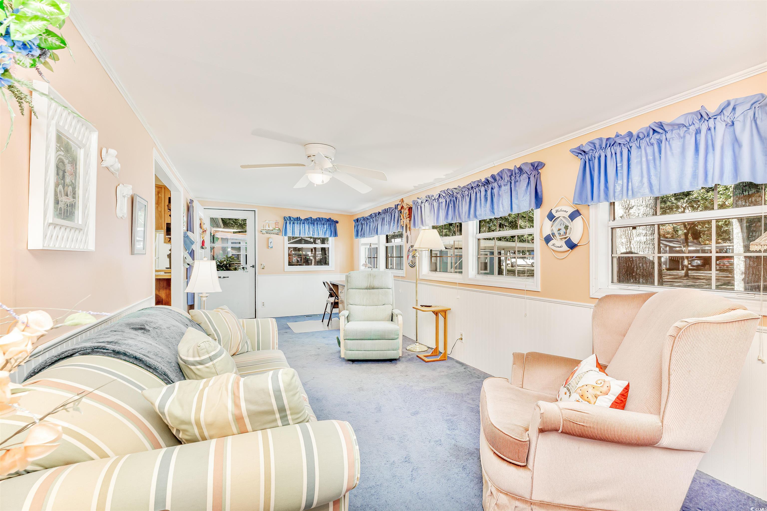 494 Clubhouse Road Murrells Inlet, SC 29576 - Photo 13 of 26 Carpeted living room featuring a ceiling fan, crown molding, and a wainscoted wall