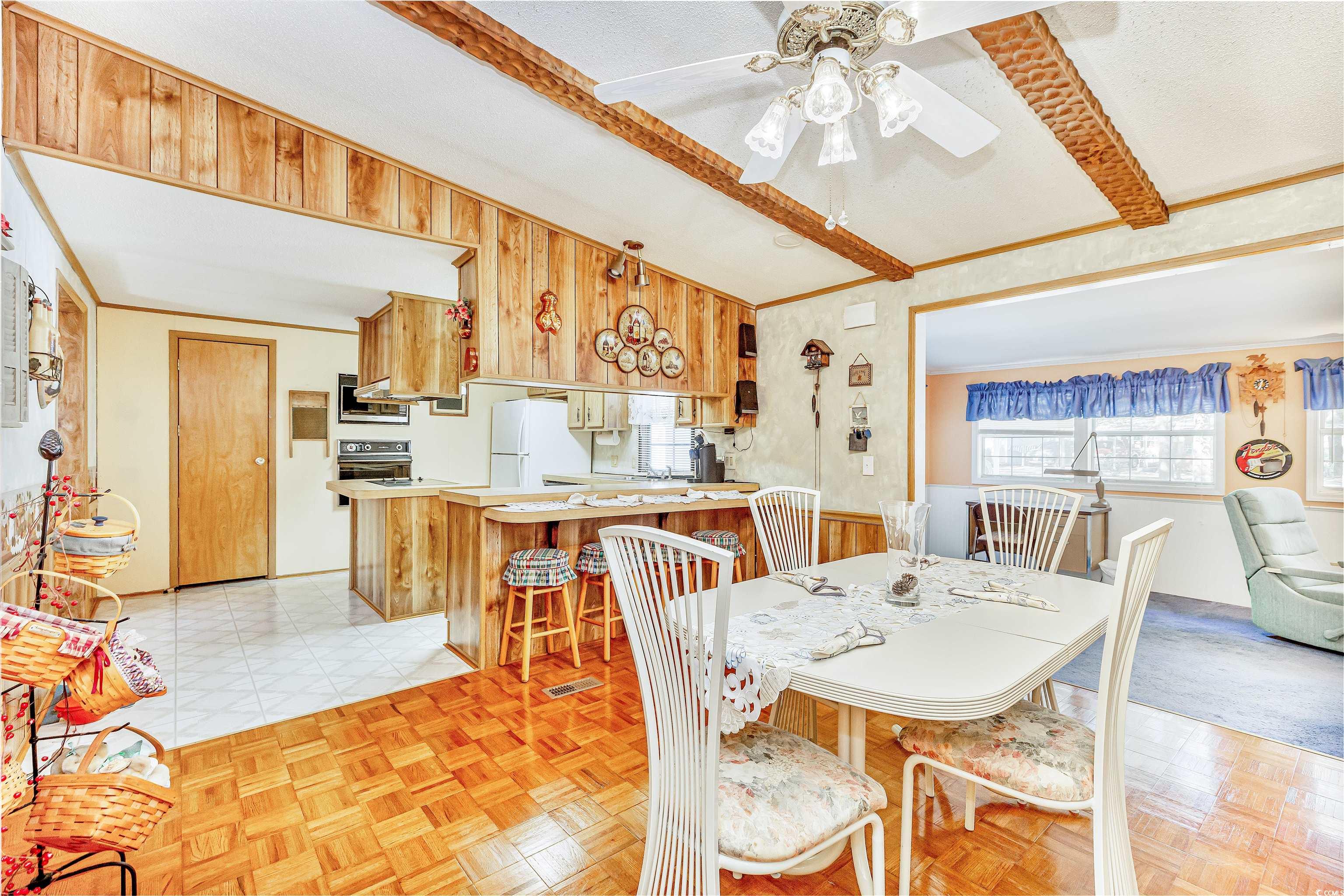 494 Clubhouse Road Murrells Inlet, SC 29576 - Photo 15 of 26 Dining room with ceiling fan and wood walls