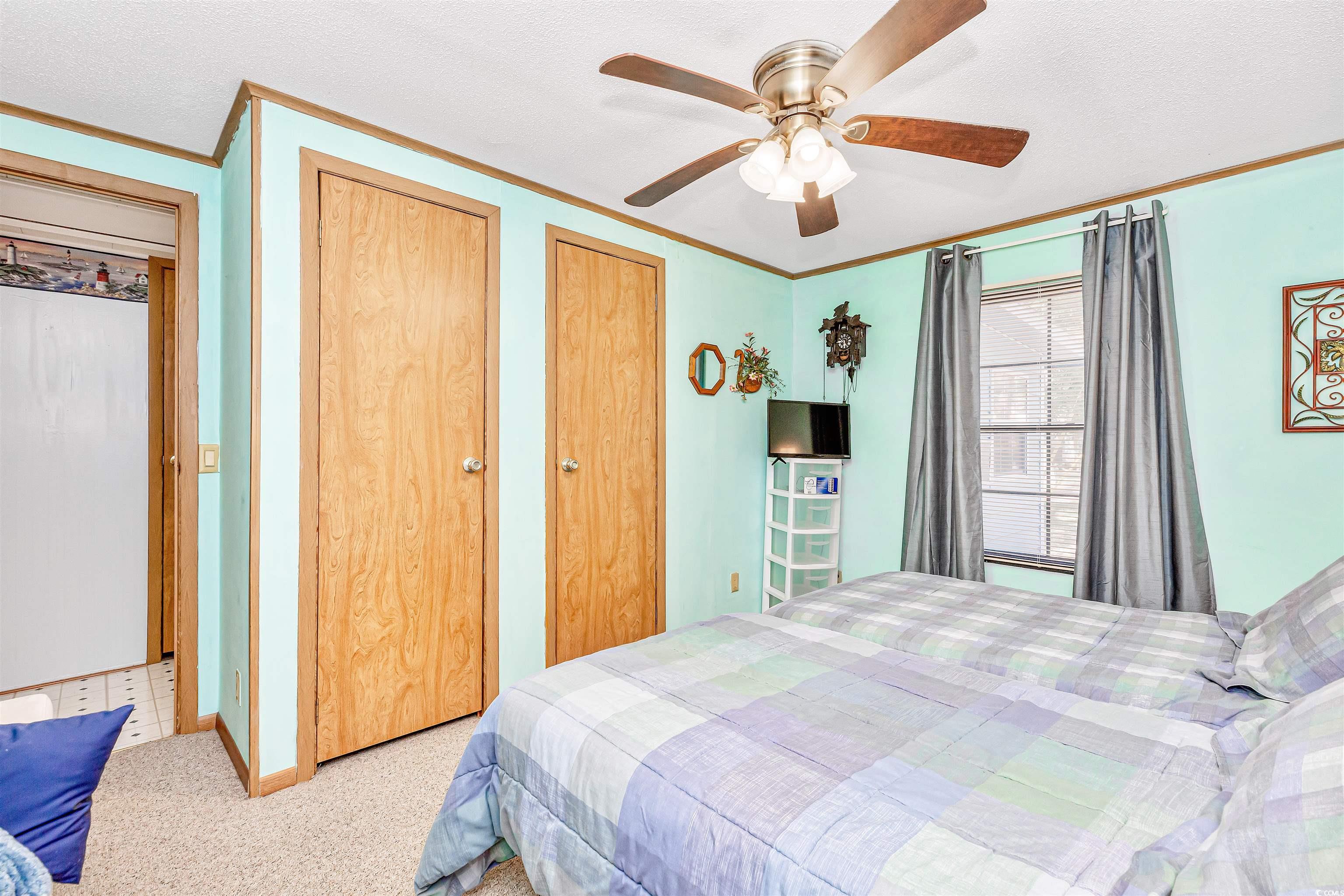 494 Clubhouse Road Murrells Inlet, SC 29576 - Photo 18 of 26 Carpeted bedroom with ornamental molding, multiple closets, a ceiling fan, and baseboards