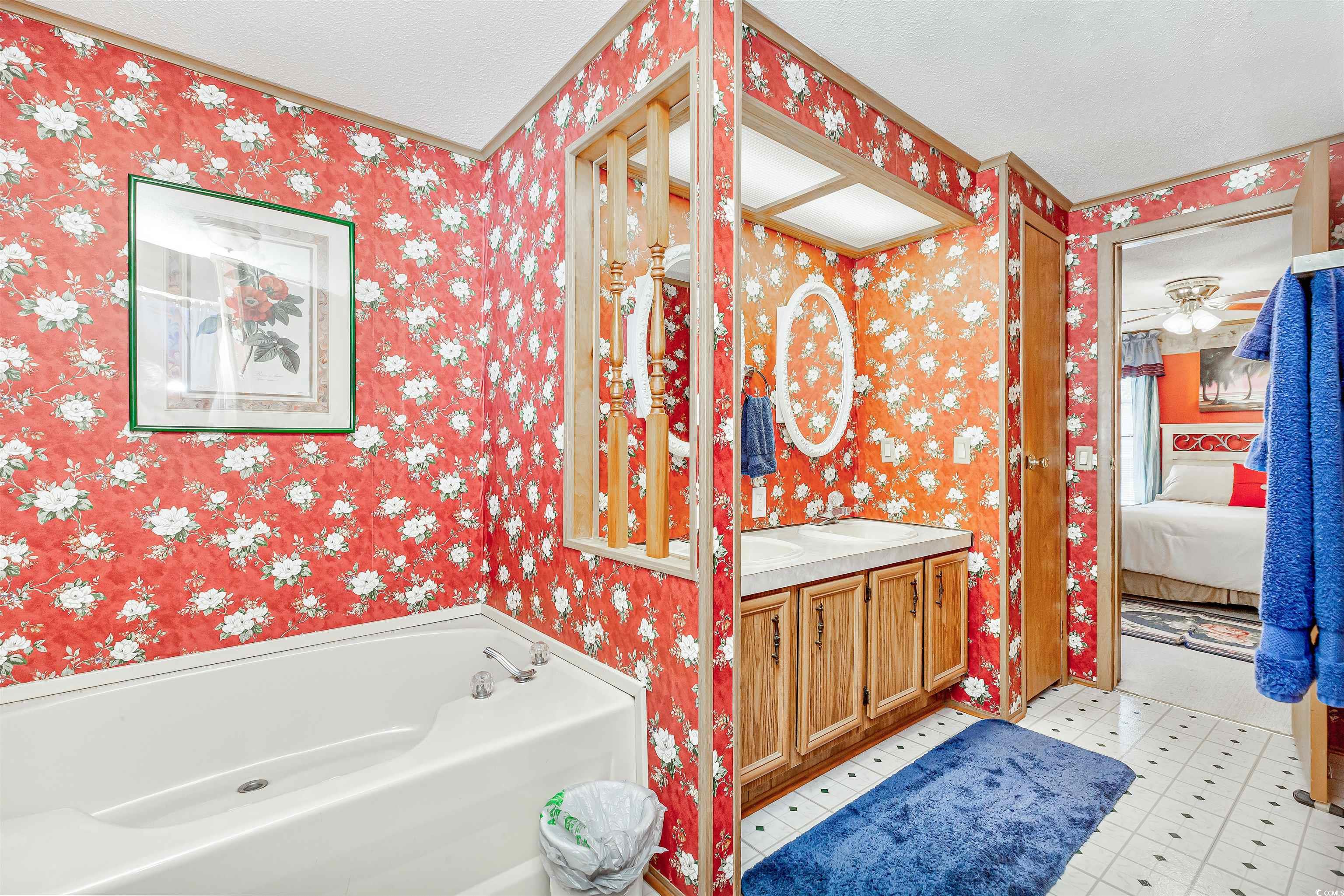 494 Clubhouse Road Murrells Inlet, SC 29576 - Photo 23 of 26 Full bath featuring wallpapered walls, vanity, a garden tub, connected bathroom, and a textured ceiling