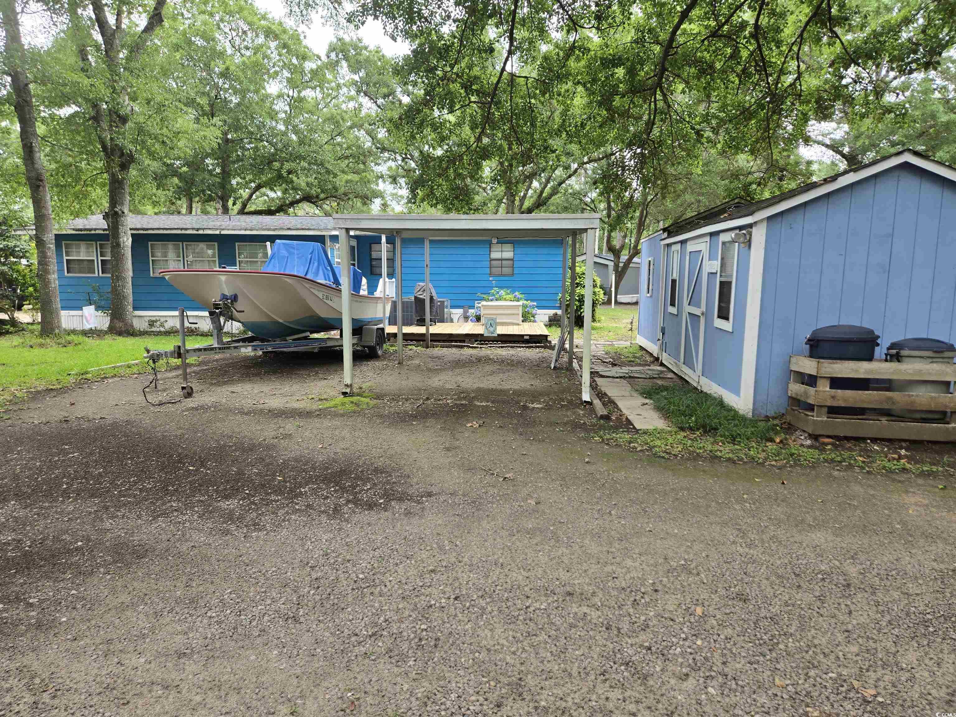 494 Clubhouse Road Murrells Inlet, SC 29576 - Photo 5 of 26 Manufactured / mobile home with view of wooded area and asphalt driveway