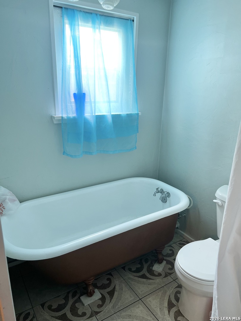 552 Diaz Street Uvalde, TX 78801 - Photo 9 of 14 a bathroom with a toilet bathtub and window