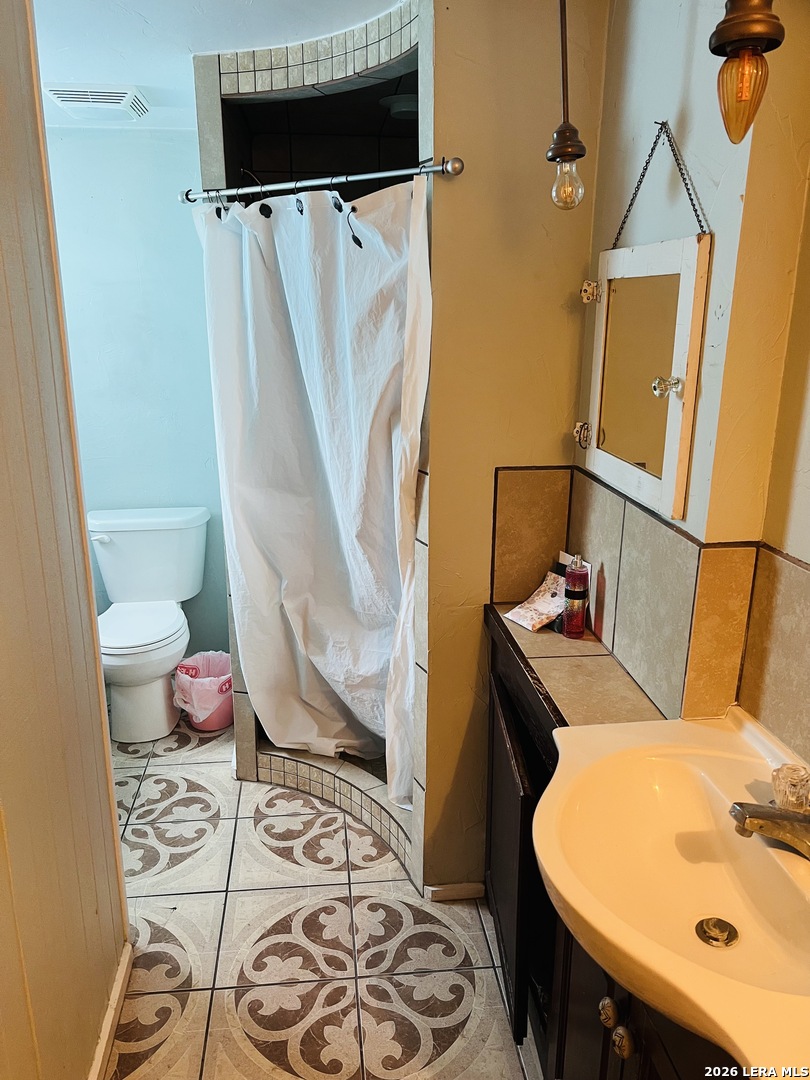 552 Diaz Street Uvalde, TX 78801 - Photo 10 of 14 a bathroom with a sink and mirror with bathtub