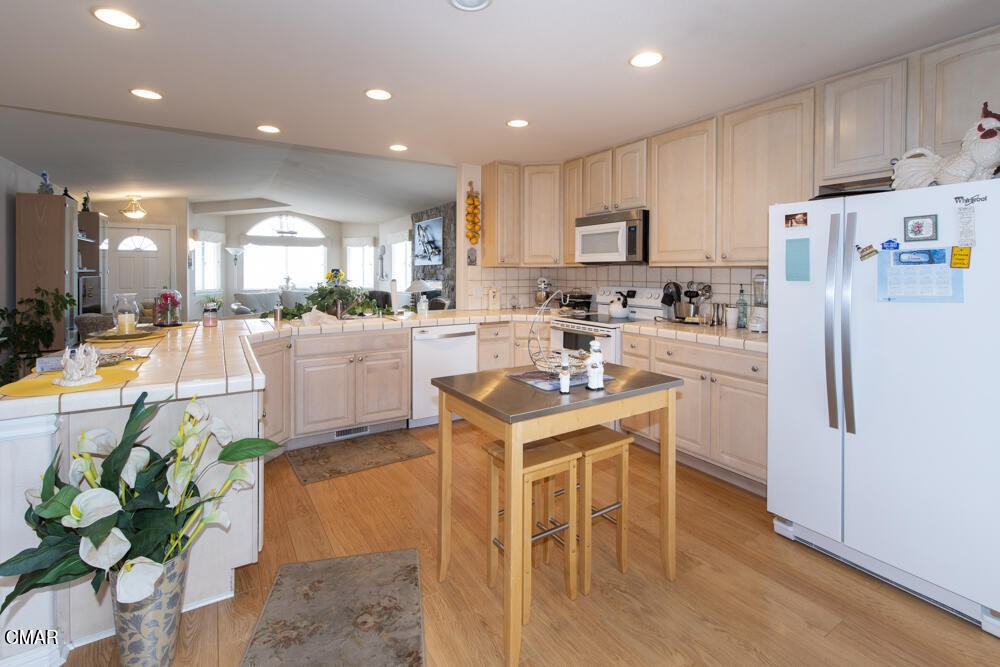 970 Glass Beach Drive Fort Bragg, CA 95437 - Photo 10 of 26 a kitchen with stainless steel appliances kitchen island granite countertop a refrigerator a stove a sink a dining table and chairs