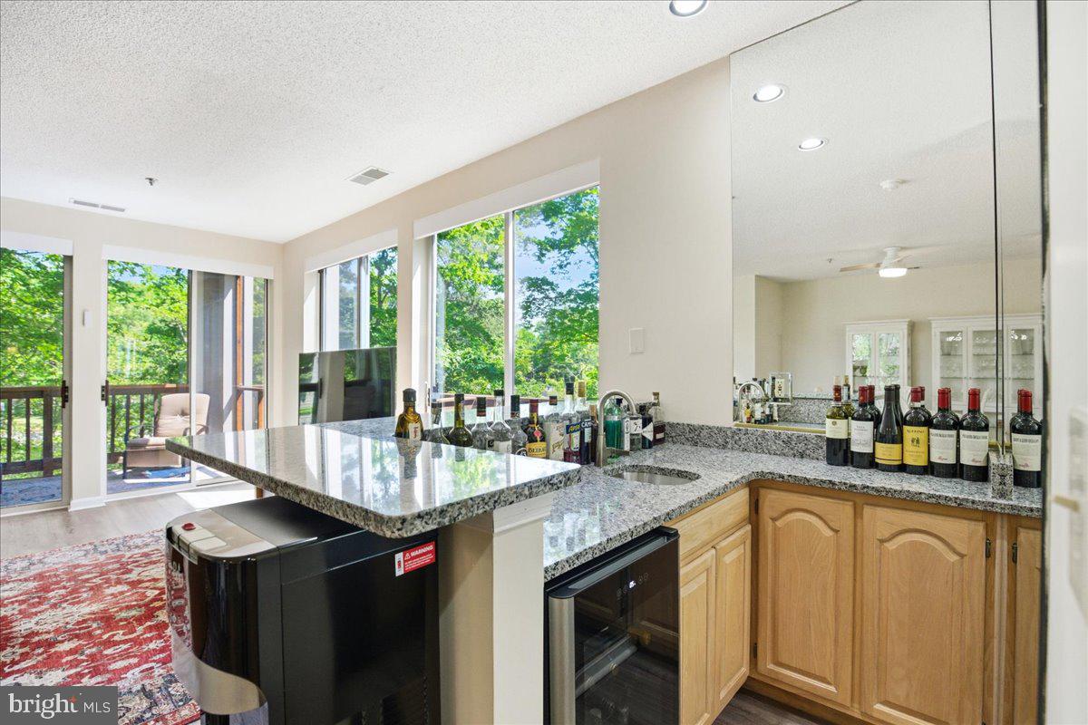 1126 Back Creek Loop, Unit 1126 Solomons, MD 20688 - Photo 16 of 47 Wet bar with bev fridge, granite matches kitchen