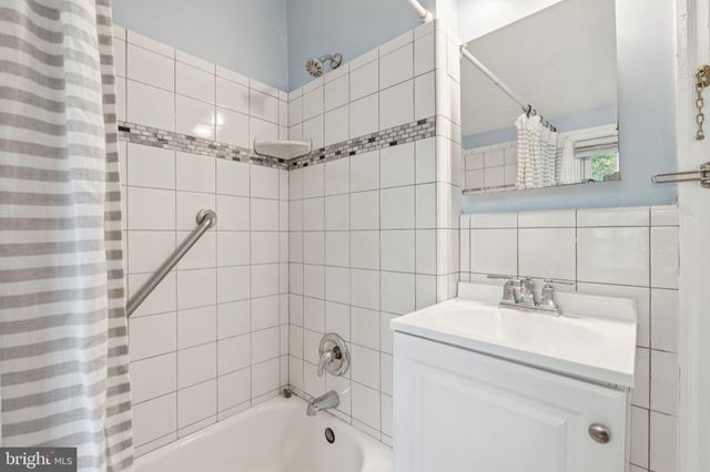 a bathroom with a shower a sink and mirror