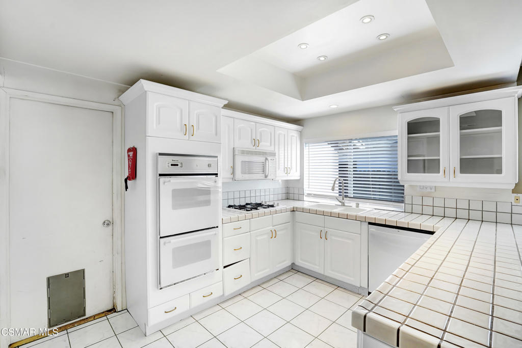 2872 Galena Avenue Simi Valley, CA 93065 - Photo 3 of 20 a kitchen with white cabinets and appliances